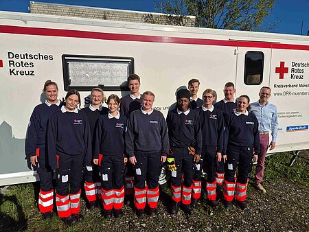 Sanitätsausbildung 12 Personen in DRK-Einsatzkleidung vor einer Unfallhilfsstation